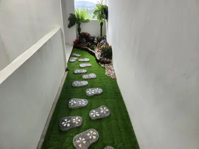 a hallway with stepping stones on the grass at Cameron Highland 910 The Garden 3BR 6 Pax in Brinchang