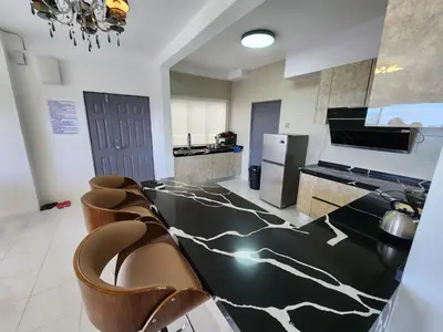 a kitchen with a black and white counter top at Cameron Highland 910 The Garden 3BR 6 Pax in Brinchang