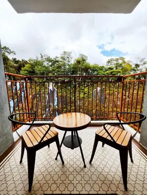 a balcony with two chairs and a table on a balcony at Cameron Highland 623 London style 10pax in Brinchang