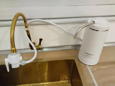 a kitchen sink with a coffee mug next to a mixer at Executive White Houze in Kepala Batas