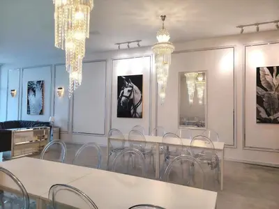 a dining room with chandeliers and a table and chairs at Executive White Houze in Kepala Batas