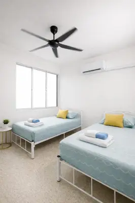 two beds in a room with a ceiling fan at 3 Bedrooms Single Storey Terrace at Taman Inderawasih ,12mins to Penang Bridge , 5mins to Sunway Carnival Mall in Butterworth