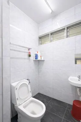 a white bathroom with a toilet and a sink at 3 Bedrooms Single Storey Terrace at Taman Inderawasih ,12mins to Penang Bridge , 5mins to Sunway Carnival Mall in Butterworth