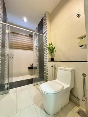 a white bathroom with a toilet and a shower at Botani Pool Villa 5R4B 14pax Karaoke BBq in Ipoh