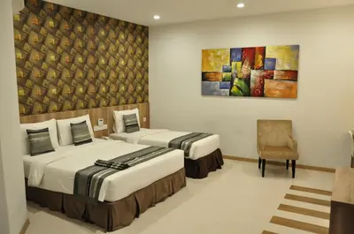 a room with two beds and a painting on the wall at Valya Hotel, Ipoh in Ipoh