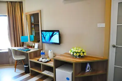 a room with a desk and a tv on a wall at Valya Hotel, Ipoh in Ipoh