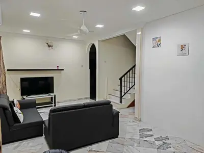 a living room with two chairs and a television at Be Stay Ipoh with parking - 14pax, 5Rooms in Ipoh