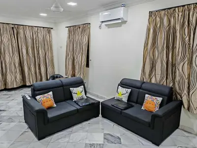 a living room with two black leather couches at Be Stay Ipoh with parking - 14pax, 5Rooms in Ipoh