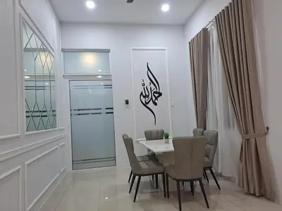 a dining room with a white table and chairs at Tiara Homestay Bandar Baru Kuala Lipis in Kuala Lipis