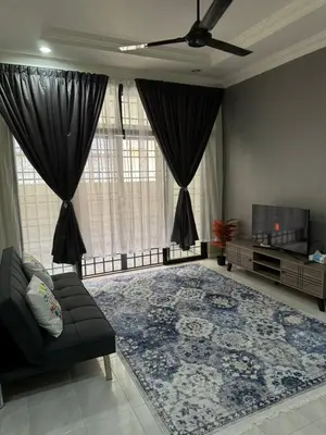 a living room with a couch and a large rug at Teratak Perdana in Sungai Petani