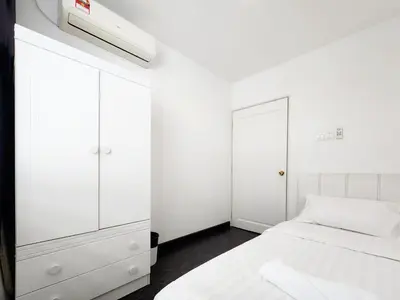 a white bedroom with a bed and a white cabinet at Georgetown Stay in George Town