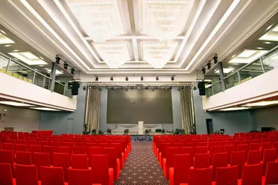 an empty auditorium with red chairs and a screen at Olive Tree Hotel Penang in Bayan Lepas