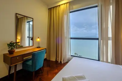a bedroom with a desk and a bed and a mirror at Penang Beachfront Seaview Residences in Tanjong Tokong