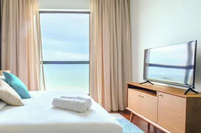 a hotel room with a bed and a television at Penang Beachfront Seaview Residences in Tanjong Tokong