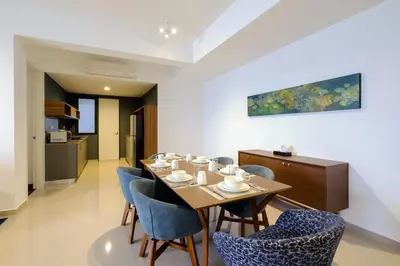 a dining room with a table and blue chairs at Penang Beachfront Seaview Residences in Tanjong Tokong