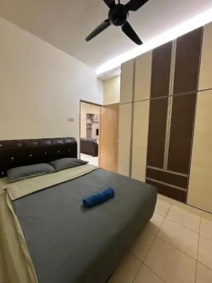 a bedroom with a large bed with a ceiling fan at StichStay Cameron in Tanah Rata