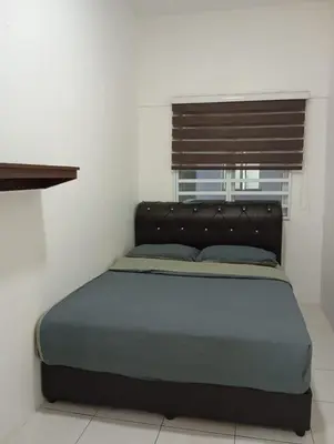 a bedroom with a bed with a black headboard and a window at StichStay Cameron in Tanah Rata