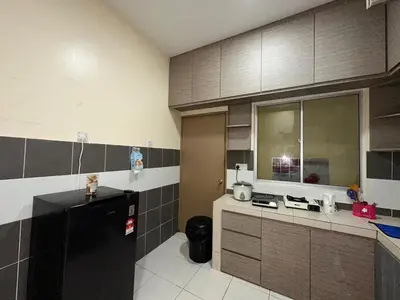 a kitchen with a black refrigerator and brown cabinets at StichStay Cameron in Tanah Rata