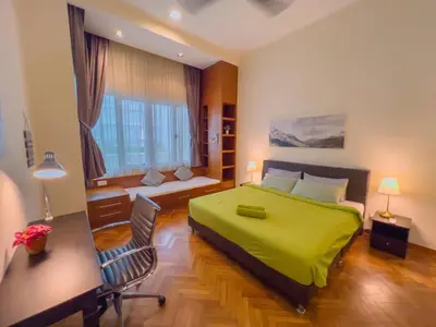 a bedroom with a green bed and a desk at Straits Quay By The Marina 1BR Family Suite in Tanjong Tokong