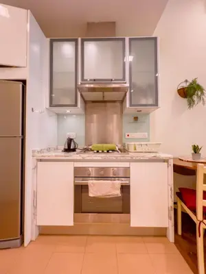 a kitchen with white cabinets and a stove at Straits Quay By The Marina 1BR Family Suite in Tanjong Tokong
