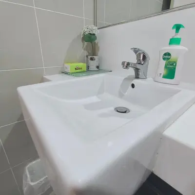 a white sink in a bathroom with a mirror at 118 Island Plaza Seaview Family Suite 5Pax 1Carpark in George Town