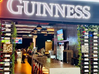 a restaurant with a bar and a sign that reads guinness at 118 Island Plaza Seaview Family Suite 5Pax 1Carpark in George Town