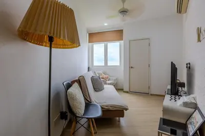 a bedroom with a bed and a lamp and a chair at 118 Island Plaza Seaview Family Suite 5Pax 1Carpark in George Town