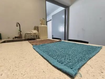 a bed with a blue rug on top of it at Tanjung Bungah Holiday Home 4BR 20Pax 6Carpark in Tanjung Bungah