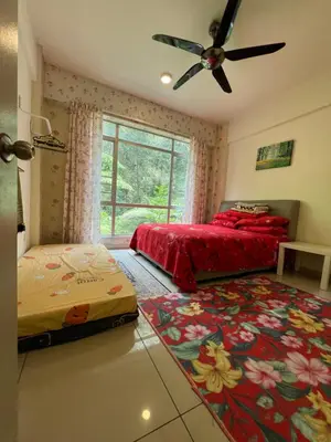 a bedroom with two beds and a ceiling fan at Cameronian Lodge by AziziCameron in Tanah Rata