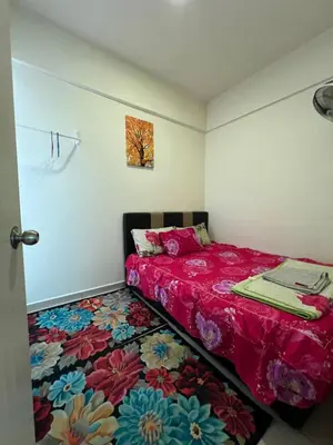 a bedroom with a red bed with a colorful carpet at Cameronian Lodge by AziziCameron in Tanah Rata