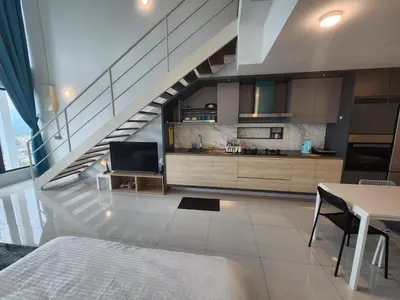 a living room with a staircase with a table and a television at Sunrise Gurney Spacious Comfort Suite - Penang Gurney Drive in George Town