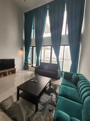 a living room with a green couch and a table at Sunrise Gurney Spacious Comfort Suite - Penang Gurney Drive in George Town