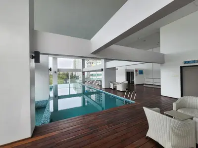 an indoor swimming pool in a building with wooden floors at Sunrise Gurney Spacious Comfort Suite - Penang Gurney Drive in George Town