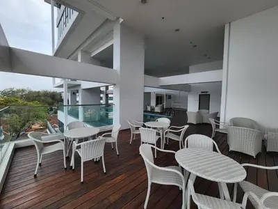 a room with tables and chairs on a balcony at Sunrise Gurney Spacious Comfort Suite - Penang Gurney Drive in George Town