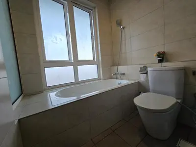 a bathroom with a tub and a toilet and a window at The Octagon -The City Centre Signature Suite in Ipoh in Ipoh