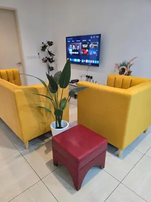 a lobby with three yellow chairs and a red stool at The Octagon -The City Centre Signature Suite in Ipoh in Ipoh