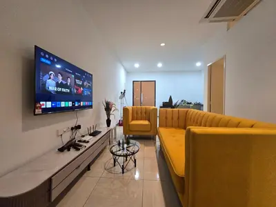 a living room with couches and a flat screen tv at The Octagon -The City Centre Signature Suite in Ipoh in Ipoh