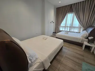a hotel room with two beds and a window at The Octagon -The City Centre Signature Suite in Ipoh in Ipoh