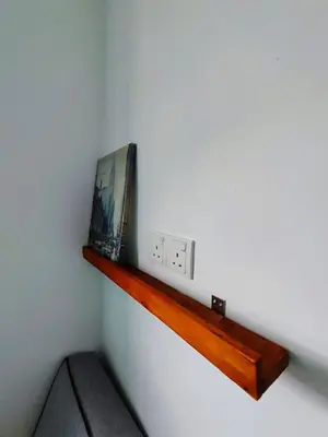 a shelf on a wall with a picture on it at Sunny Nest in Gopeng