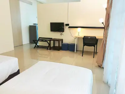 a room with a bed and a table and a television at Cozy Private Room for Relaxing Stays in Nibung Tebal