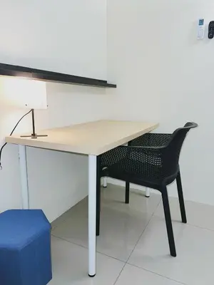 a desk with a black chair and a table with a lamp at Cozy Private Room for Relaxing Stays in Nibung Tebal