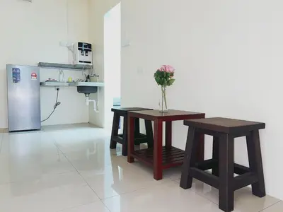 a kitchen with two tables and a refrigerator at Cozy Private Room for Relaxing Stays in Nibung Tebal