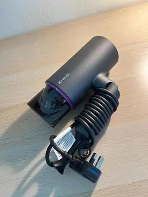 a black flashlight on a table with a remote control at Cozy Private Room for Relaxing Stays in Nibung Tebal