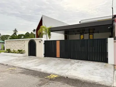 a house with a black gate and a driveway at Taiping Corner Homestay in Taiping