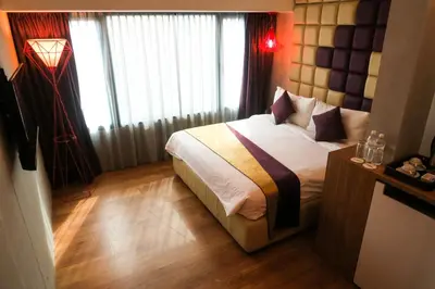 a bedroom with a bed in a room with windows at Le Dream Boutique Hotel in George Town