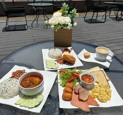 a table with different types of food on plates at Le Dream Boutique Hotel in George Town