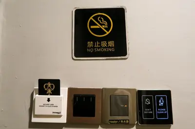 a no smoking sign on a wall next to other signs at Le Dream Boutique Hotel in George Town