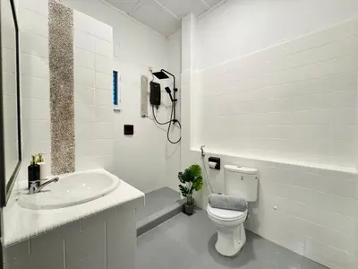 a white bathroom with a toilet and a sink at Greentown Villa - Ipoh City Centre near Ipoh Parade by IWH Suites in Ipoh
