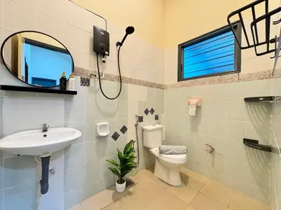 a bathroom with a sink and a toilet and a mirror at Greentown Villa - Ipoh City Centre near Ipoh Parade by IWH Suites in Ipoh