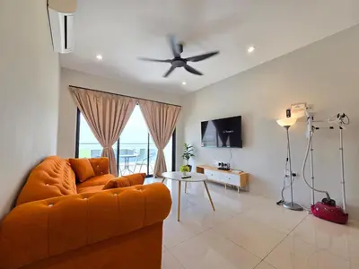 an orange couch in a living room with a ceiling fan at Manhattan Condo - Ipoh Merveille Luxe Stay in Ipoh
